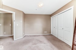 Carpeted room with neutral-toned walls, white trim, and a ceiling light fixture - 
