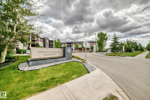 Entry signage for Aurora Greens featuring stone cladding and a large display panel - 215 1510 Watt Drive, Edmonton, AB 