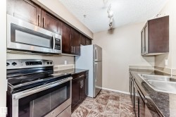 Kitchen featuring stainless steel appliances including a range, microwave, and refrigerator - 