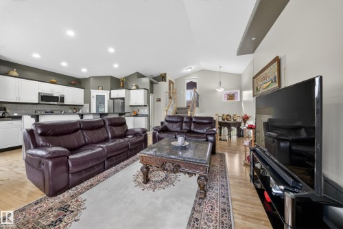 Open concept living area featuring wood-finish flooring, recessed lighting, and a vaulted ceiling - 4113 59 Street, Beaumont, AB 