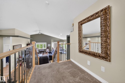 Upper-level landing featuring textured carpeting and a decorative wall-mounted mirror - 4113 59 Street, Beaumont, AB 