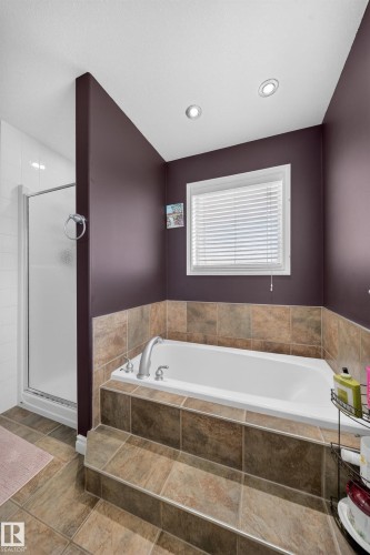 Soaking tub with tiled surround, accompanied by a separate glass-enclosed shower - 4113 59 Street, Beaumont, AB 