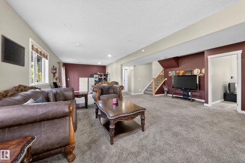 Spacious lower-level area featuring plush carpeting, recessed lighting, and a prominent accent wall - 4113 59 Street, Beaumont, AB 