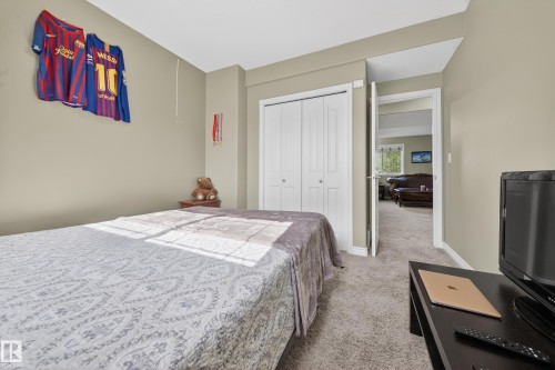 Neutral-toned walls and plush carpet flooring complement a white bi-fold closet door - 4113 59 Street, Beaumont, AB 