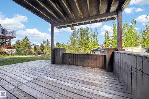 Expansive covered wood-finish deck with built-in storage and railing - 4113 59 Street, Beaumont, AB 