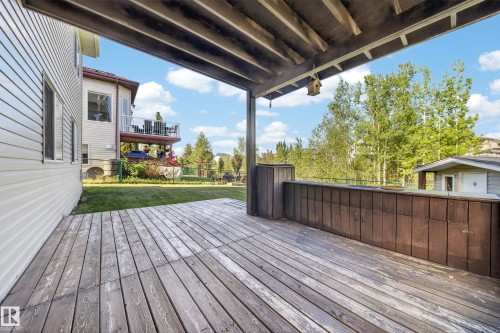 Covered wooden deck with slatted flooring and a built-in privacy wall - 4113 59 Street, Beaumont, AB 