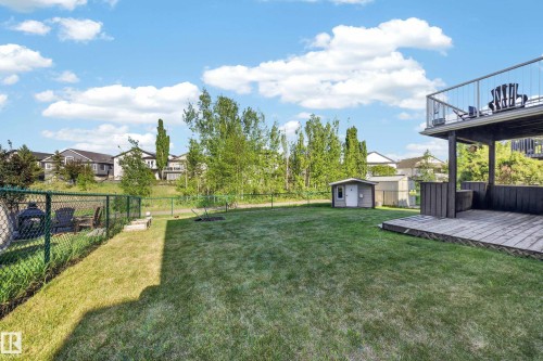 Expansive backyard featuring a lush lawn, chain link fencing, and a detached storage shed - 4113 59 Street, Beaumont, AB 