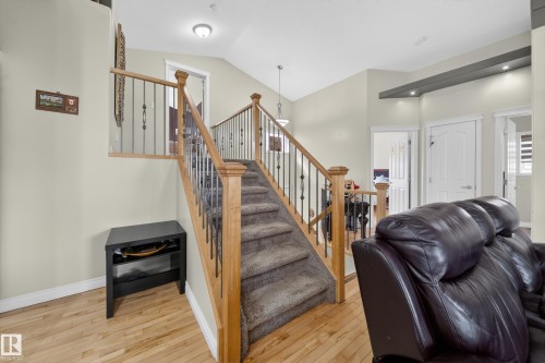 Carpeted stairway featuring wooden newel posts and metal spindles - 4113 59 Street, Beaumont, AB 