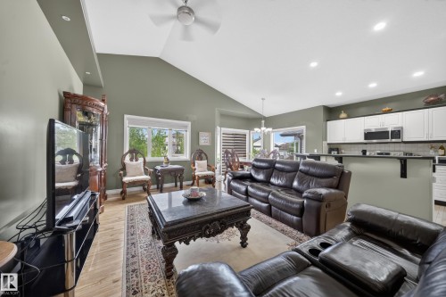 Spacious living area featuring vaulted ceilings, recessed lighting, and wood-finish flooring - 4113 59 Street, Beaumont, AB 