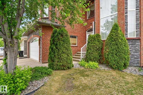 Bay window with vertical blinds and decorative valances, wall sconces, ceiling crown molding, and light-toned carpeting - 1508 Palmer Close, Edmonton, AB 