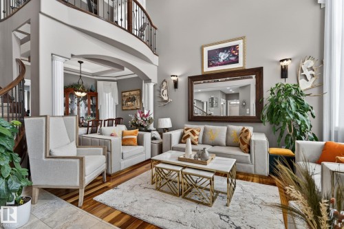 Brick exterior featuring an arched double entry door with decorative glass, a grand two-story window, stacked stone accents, and a concrete pathway with steps - 1508 Palmer Close, Edmonton, AB 