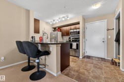 Kitchen with dark wood cabinetry, stainless steel appliances, and a breakfast bar featuring a black countertop - 