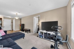 Carpeted living area featuring light beige wall tones and white trim - 