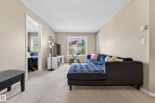 Carpeted living area featuring light-toned walls and white trim - 225 1510 Watt Drive, Edmonton, AB - Indoor Photo Showing Living Room