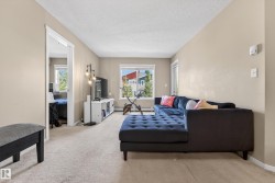 Carpeted living area featuring light-toned walls and white trim - 