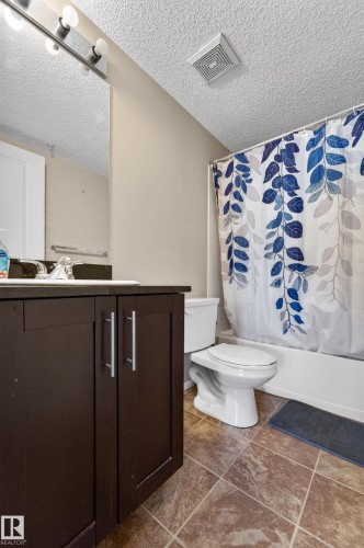 Bathroom featuring a dark wood-finish vanity with silver-tone hardware, a rectangular sink, and a framed mirror - 225 1510 Watt Drive, Edmonton, AB - Indoor Photo Showing Bathroom