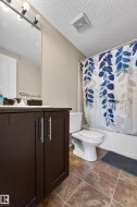 Bathroom featuring a dark wood-finish vanity with silver-tone hardware, a rectangular sink, and a framed mirror - 
