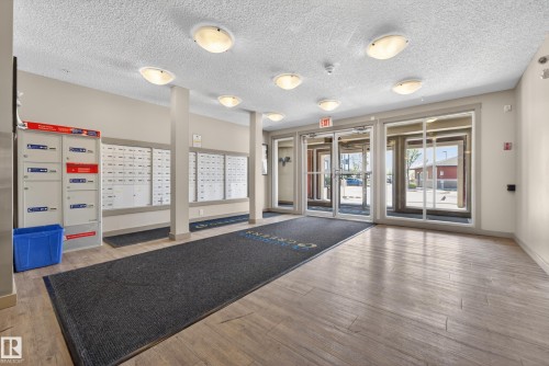 Building lobby featuring light wood-finish flooring and multiple flush-mount ceiling lights - 225 1510 Watt Drive, Edmonton, AB - Indoor