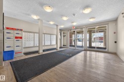 Building lobby featuring light wood-finish flooring and multiple flush-mount ceiling lights - 