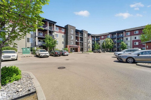 Contemporary multi-story building featuring varied exterior finishes including stone accents, siding, and multiple private balconies - 225 1510 Watt Drive, Edmonton, AB - Outdoor With Facade