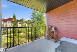 Private balcony with concrete flooring, black metal railing, and horizontal wood-finish siding - 
