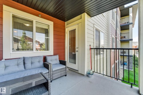 Exterior balcony with a concrete surface, black metal railings, and a white framed glass door - 225 1510 Watt Drive, Edmonton, AB - Outdoor With Deck Patio Veranda With Exterior