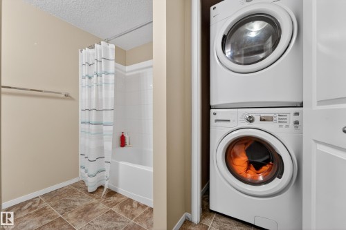 Full-size stacked laundry appliances - 225 1510 Watt Drive, Edmonton, AB - Indoor Photo Showing Laundry Room