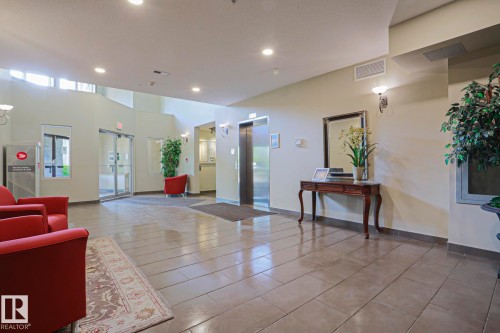 Lobby area featuring large format tile flooring, recessed lighting, and a stainless steel elevator - 117 160 Magrath Road, Edmonton, AB - Indoor
