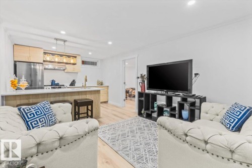 Open-concept living area featuring light wood-finish flooring and recessed lighting - 6720 29 Avenue, Edmonton, AB 