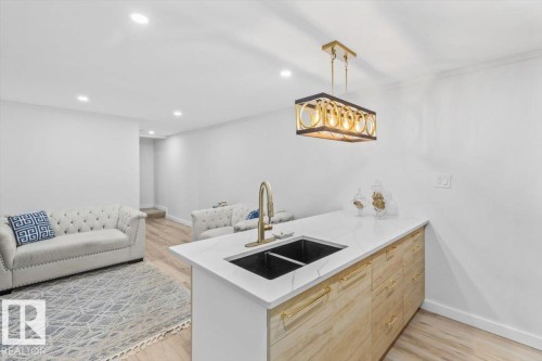 Kitchen island with a dual black sink and a gold-finish faucet - 6720 29 Avenue, Edmonton, AB 