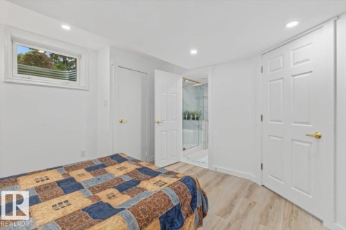 Bedroom featuring light wood-finish flooring, recessed lighting, and a window with a window well - 6720 29 Avenue, Edmonton, AB 