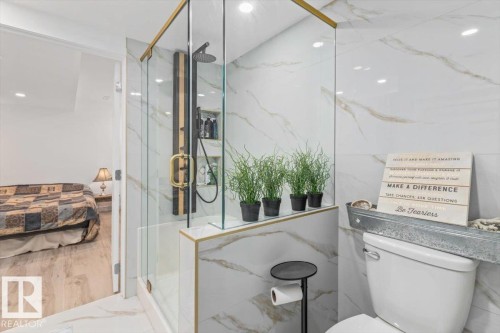 Glass-enclosed shower with gold-tone accents, a rain shower head, and an integrated shelf - 6720 29 Avenue, Edmonton, AB 