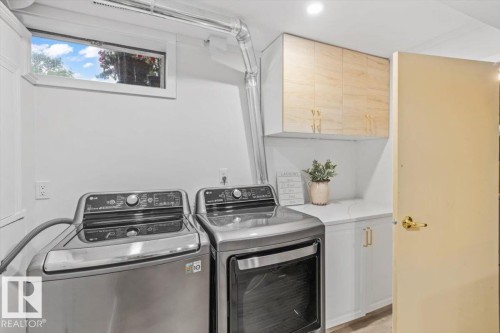 Dedicated laundry area featuring a built-in countertop, light wood-finish upper cabinetry, white lower cabinetry with gold-tone hardware, and a high window - 6720 29 Avenue, Edmonton, AB 