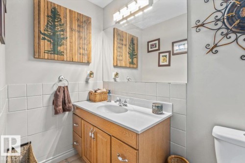 Bathroom vanity featuring a light wood-finish cabinet, white countertop, and integrated sink - 6720 29 Avenue, Edmonton, AB 