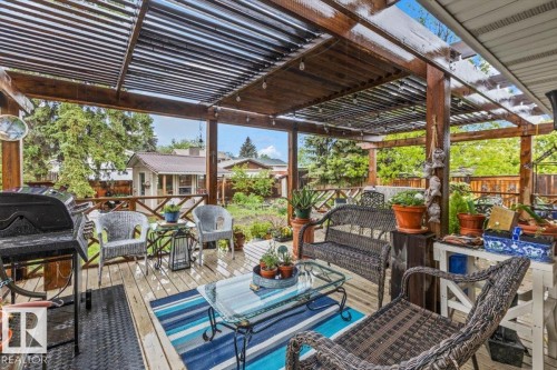Expansive wooden deck featuring a slatted pergola roof and string lighting - 6720 29 Avenue, Edmonton, AB 
