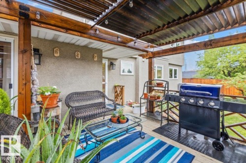 Covered outdoor deck featuring natural wood beams and slatted ceiling - 6720 29 Avenue, Edmonton, AB 