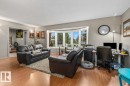 Living area featuring wood-finish flooring and a prominent bay window - 6720 29 Avenue, Edmonton, AB 