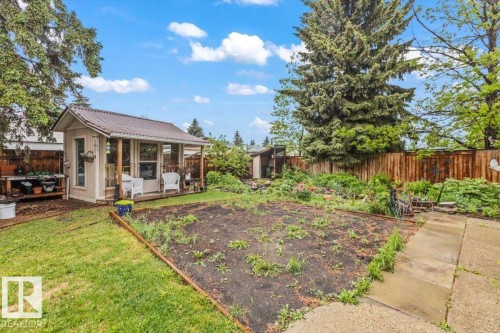 Backyard space featuring a detached outbuilding with a porch and metal roof - 6720 29 Avenue, Edmonton, AB 
