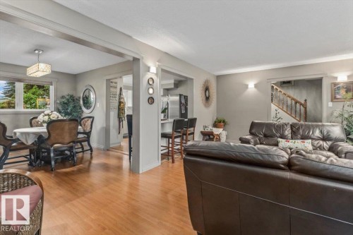 Open-concept living space featuring wood-finish flooring, recessed lighting, and a staircase with a wooden banister - 6720 29 Avenue, Edmonton, AB 