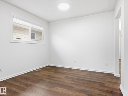 Interior room featuring wood-finish flooring, white walls, and a white trim package - 13316 136 Avenue, Edmonton, AB 