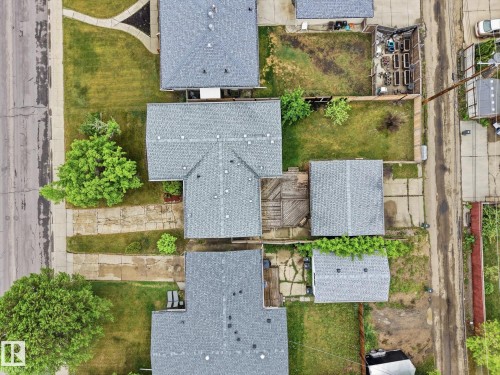 Property featuring a main residence with a gray shingle roof, a detached garage with a matching shingle roof, and a wood deck - 13316 136 Avenue, Edmonton, AB 