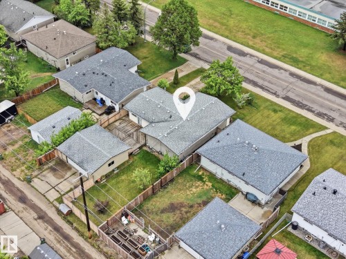 Property featuring a shingled roof, light-colored exterior siding, and a wooden deck - 13316 136 Avenue, Edmonton, AB 