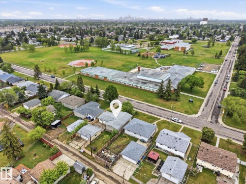 Property featuring a light-colored shingle roof and a fenced backyard, located within a residential neighborhood - 13316 136 Avenue, Edmonton, AB 