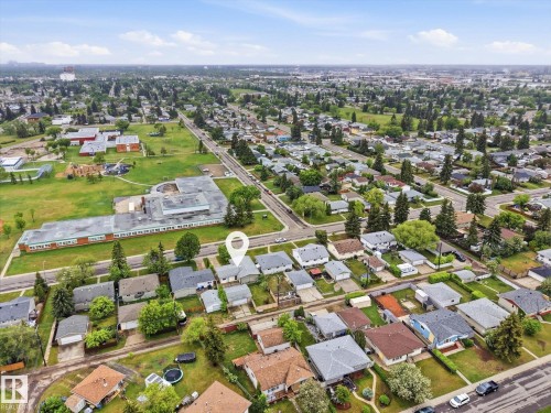 Aerial view showcasing a residential neighborhood with numerous single-story homes, mature trees, and paved streets - 13316 136 Avenue, Edmonton, AB 