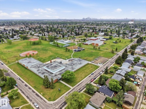 Expansive neighborhood featuring numerous residential properties with dark shingle roofs, surrounded by mature trees - 13316 136 Avenue, Edmonton, AB 