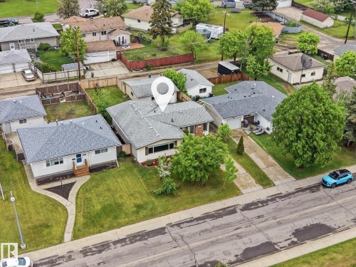 Single-story residence featuring a gray shingle roof, light-toned exterior siding, and a paved driveway - 13316 136 Avenue, Edmonton, AB 