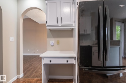 Built-in desk area featuring white cabinetry, a single drawer, and a dedicated workspace - 16811 91 Street, Edmonton, AB 