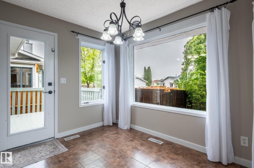 Dining area featuring a large picture window and additional window with exterior views - 16811 91 Street, Edmonton, AB 