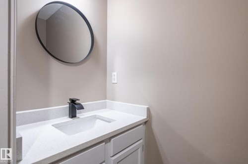 Vanity featuring an undermount sink, a white countertop, and matte black faucet - 16811 91 Street, Edmonton, AB 