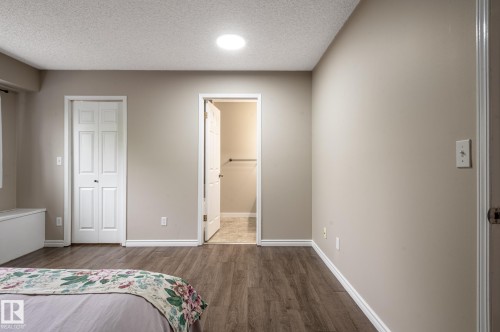 Interior room featuring wood-finish flooring, neutral wall tones, and white baseboards - 16811 91 Street, Edmonton, AB 